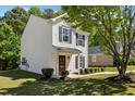 Inviting home featuring neat landscaping and a welcoming front porch, surrounded by mature trees and green foliage at 5801 Forest Point Rd, Raleigh, NC 27610