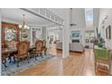 Open-concept living room with hardwood floors, fireplace, and views into the dining room and kitchen at 6512 Southern Times Dr, Raleigh, NC 27603
