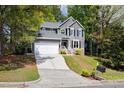 Charming gray home with white trim, lush landscaping, and a two-car garage on a sunny day at 7 Wythebrook Ln, Durham, NC 27713