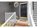 Close-up of a stylish front door with a decorative window and white railing at 7 Wythebrook Ln, Durham, NC 27713