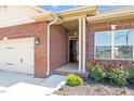 A view of the front entry and rose garden of this attractive red brick home at 8 Pal Ct, Benson, NC 27504