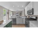 Modern kitchen with stainless steel appliances, an island and an open view to the living room at 8005 Somerdale Dr, Durham, NC 27713