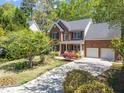 Beautiful brick home with a two-car garage, landscaped yard, and mature trees at 8212 Duck Creek Dr, Raleigh, NC 27616