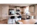 Bright kitchen featuring white cabinets, stainless steel appliances, and a center island with barstool seating at 8764 Kenridge Ln, Fuquay Varina, NC 27526