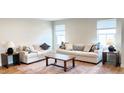 Cozy living room featuring hardwood floors, neutral-colored sofas, and a wooden coffee table at 8764 Kenridge Ln, Fuquay Varina, NC 27526