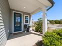 Inviting front porch with a blue door, stylish planters, and charming curb appeal on a sunny day at 937 Matterhorn Dr, Fuquay Varina, NC 27526