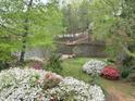 Backyard view overlooking the lake with vibrant azaleas and a tranquil waterfront at 959 Sagamore Dr, Louisburg, NC 27549
