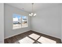 Bright dining room featuring wood flooring, a modern chandelier, and a large window for natural light at 4868 Pioneer Dr, Sanford, NC 27330