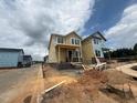 New homes under construction with yellow siding and brick foundations under a cloudy sky at 10 Relaxing Way, Pittsboro, NC 27312