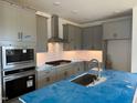 Modern kitchen with stainless steel appliances, gray cabinets and a center island at 10 Relaxing Way, Pittsboro, NC 27312