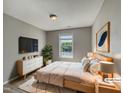 Comfortable bedroom with modern decor, a large window, and a mounted TV for relaxation at 10 Sandy Bluff Ct, Durham, NC 27703