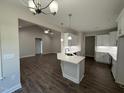 Open-concept kitchen with hardwood floors, white cabinets, modern appliances, and an island sink at 1000 Peedin Rd, Selma, NC 27576