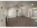 Open-concept living room with vaulted ceilings, hardwood floors, and a cozy fireplace at 1000 Peedin Rd, Selma, NC 27576