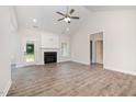 Bright living room with a fireplace, ceiling fan, and luxury vinyl flooring at 1000 Peedin Rd, Selma, NC 27576