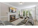 Cozy living room featuring a fireplace, large windows, and comfortable seating for a relaxing atmosphere at 1013 Whitney Springs Ct, Holly Springs, NC 27540