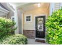 Welcoming front door with decorative wreath, stone accents, and well-manicured shrubbery at 11210 Lofty Heights Pl, Raleigh, NC 27614