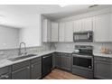 Well-lit kitchen with gray cabinets, granite countertops, and stainless steel appliances, offering a modern design at 11210 Lofty Heights Pl, Raleigh, NC 27614