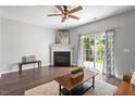 Cozy living room showcasing a fireplace, sliding glass doors, and hardwood floors at 11210 Lofty Heights Pl, Raleigh, NC 27614