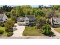 Aerial view of a two-story home with a three-car garage, mature trees, and green lawn at 1140 Buttercup Ln, Wake Forest, NC 27587