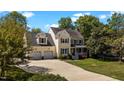 Traditional two-story home with a three-car garage, mature trees, and a well-manicured lawn at 1140 Buttercup Ln, Wake Forest, NC 27587