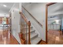 Carpeted stairway with hardwood floors, wooden railing, and white trim at 1140 Buttercup Ln, Wake Forest, NC 27587