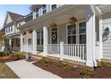 Inviting front porch with white railings and decorative hanging flower baskets at 1265 Meadow Queen Ln, Apex, NC 27502