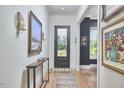 Elegant entryway featuring hardwood floors, sophisticated wall decor, a console table, and a stylish black-framed door at 1336 Courtland Dr, Raleigh, NC 27604