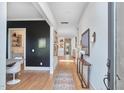 Inviting entryway with hardwood floors, black accent wall, decorative console table, and an open view into the kitchen at 1336 Courtland Dr, Raleigh, NC 27604