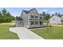 Side view of gray home with two-car garage, long driveway and manicured lawn, under a bright sky at 134 Ivy Ridge Rd, Chapel Hill, NC 27516