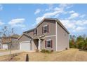 Two-story home with gray siding, white garage door, red shutters and well manicured front yard at 217 Braeburn Dr, Graham, NC 27253