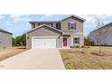 Charming two-story home boasts gray siding, a white garage door, and tidy front lawn at 217 Braeburn Dr, Graham, NC 27253