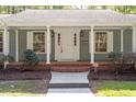Close up of a charming single-story home features a welcoming front porch with classic white columns at 2225 Whitley Dr, Durham, NC 27707