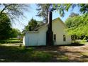Side exterior of home with a chimney and trees at 223 Gum Ave, Spring Hope, NC 27882