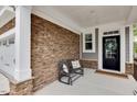 Cozy front porch with stone accent wall and a bench at 2283 Grants Pass Sta, Apex, NC 27502