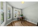 Bright home office featuring large windows, a wooden desk, and hardwood floors at 233 Pointe Park Cir, Holly Springs, NC 27540