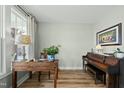 Well-lit office space with wooden floors, a piano, and a view of the outdoors at 233 Pointe Park Cir, Holly Springs, NC 27540