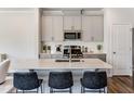 Charming kitchen with stainless appliances, island with counter seating, and hardwood floors at 236 Paramount Dr, Smithfield, NC 27577