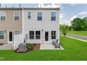 Townhome backyard featuring a small patio, green grass, and tasteful landscaping on a sunny day at 248 Paramount Dr # 25, Smithfield, NC 27577