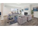 Bright living room with a fireplace, large windows, gray sofas and armchairs, and a blue patterned rug at 2613 Red Spruce Dr, Raleigh, NC 27616