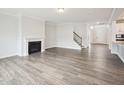 Spacious living room featuring a fireplace, wood floors, a staircase, and plenty of natural light at 2613 Red Spruce Dr, Raleigh, NC 27616
