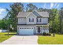 Well-maintained two-story home with attached garage, front porch with rocking chairs, and landscaping at 263 Annali Way, Wendell, NC 27591