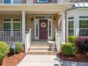 Inviting front entrance with a decorative wreath, brick steps, and manicured landscaping at 316 Hilliard Forest Dr, Cary, NC 27519