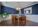 Elegant dining room with hardwood floors, wainscoting, and stylish chandelier at 3205 Silver Ore Ct, Wake Forest, NC 27587