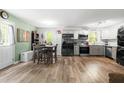 Open kitchen and dining area with stainless steel appliances and modern gray and white cabinets at 329 Cartwright Cir, Wendell, NC 27591