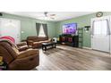 Cozy living room with a comfortable leather sofa, ceiling fan, and neutral walls and flooring at 329 Cartwright Cir, Wendell, NC 27591