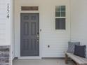 Front door entrance with an outdoor bench and decorative pillow at 373 Thompson Overlook Way, Smithfield, NC 27577