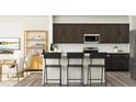 Modern kitchen with dark cabinets, white subway tile backsplash, and bar seating at the island at 385 Thompson Overlook Way, Smithfield, NC 27577