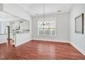 Open concept dining area featuring hardwood floors, modern light fixture, and large window at 4 Calwell Creek Dr, Chapel Hill, NC 27517