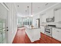 Bright kitchen with stainless steel appliances, granite countertops, and seamless flow to sunroom at 4 Calwell Creek Dr, Chapel Hill, NC 27517