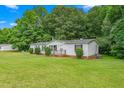 View of home's rear and side with a well-manicured lawn, featuring a small back deck at 4047 Mistletoe Dr, Burlington, NC 27217